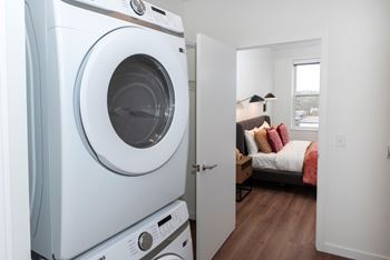 a white washer and dryer in a room with a bedroom